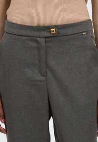 Grijze op maat gemaakte broeken met een gladde textuur, voorzien van een vierkante gouden hardware-accent bij de taille en slanke zijzakken.