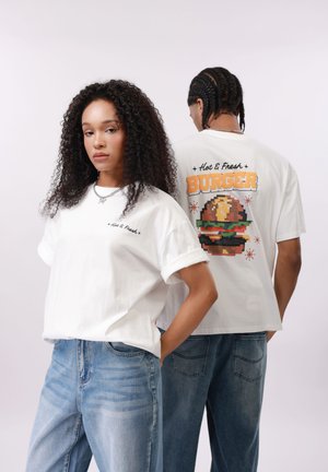 To modeller bærer hvide T-shirts med teksten "Hot & Fresh"; bagsiden af trøjen har en pixel-art burger og teksten "BURGER" i orange.