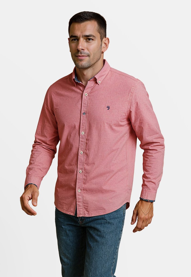 Rode button-up overhemd van een geweven stof, met lange mouwen en een contrasterende kraag. Het heeft een klein logo op de borst. Gecombineerd met blauwe jeans.