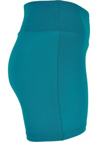 Pantalones cortos de tela elástica en tono verde azulado con una cintura alta, textura suave y un diseño sin costuras. El dobladillo está acabado con una costura limpia para mayor durabilidad.