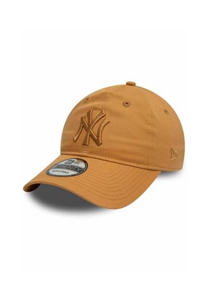 Casquette New Era en tissu brun clair. Présente un logo NY en relief, une visière incurvée et une sangle ajustable. Surface texturée avec des accents brodés.