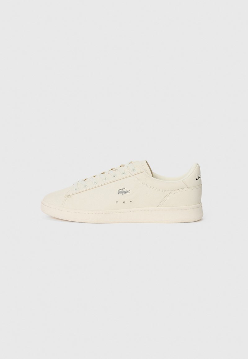 Krém színű sneaker sima textúrával, kerek formával, fűzős dizájnnal, finom perforációkkal és ezüst színű logóval az oldalán.