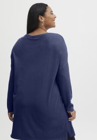 Maglione a maniche lunghe, blu navy, con un ampio scollo e spacchi laterali sull'orlo. Tessuto morbido con una vestibilità rilassata.