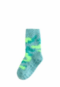 Turkos fluffiga strumpor med en texturerad yta, prydda med ljusgröna abstrakta mönster. Sålen har en prickig greppdesign.