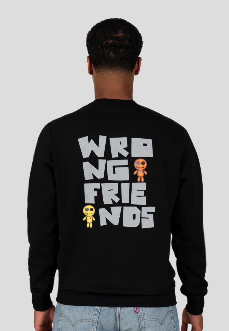 Zwart sweatshirt met de tekst "WRONG FRIENDS" in het grijs en cartoonfiguren in het geel en oranje. Zacht materiaal, ronde hals en geribde manchetten.