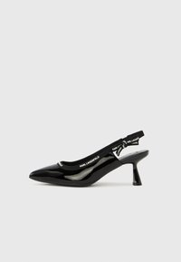 Čierne lodičky na opätku so slingback remienkom z lakovanej kože s špicatou špičkou, s elastickým pásikom potlačeným logom a stredne vysokým zahnutým opätkom.