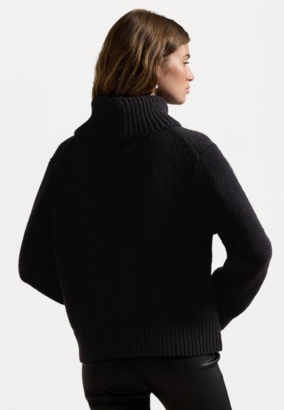 Sort strikket sweater med høj ribbet krave, afslappet pasform og ribbede nederste detaljer. Den strukturerede stof giver et blødt udseende.