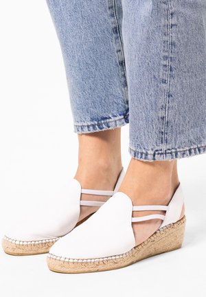 Witte leren espadrille-wedges met een geweven jute hak. Beschikt over een glad oppervlak en dubbele banden rond de enkel. Casual ontwerp.