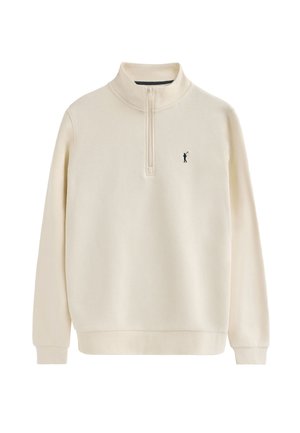 Crème trui met een kwart-rits kraag, zacht fleece materiaal, geribbelde manchetten en een kleine zwarte geborduurde figuur op de linkerkant van de borst.