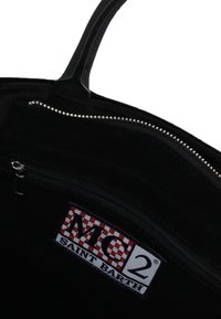 Intérieur en daim noir d'un sac avec une poche zippée. Présente une étiquette à carreaux rouges et blancs avec l'inscription "MC2 SAINT BARTH." Fermeture éclair en métal argenté.