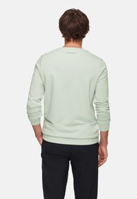 Mint green sweatshirt with a round neckline, ribbed cuffs, and hem. Features a subtle logo at the back, made from soft, stretchy material.