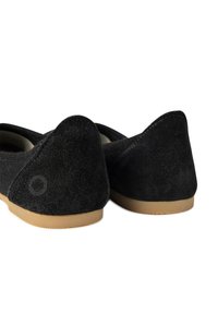 Černé semišové boty s jemnou texturou, vybavené zaoblenými podpatky a béžovými gumovými podrážkami. Zpětný pohled zdůrazňuje tvar a detaily šití.