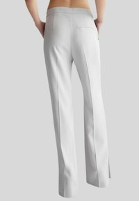 Pantaloni su misura grigio chiaro caratterizzati da un design a gamba larga, una texture liscia e una tasca posteriore singola con un sottile dettaglio a fessura.