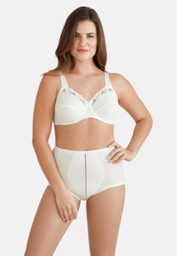 Ivoor bh met kantafwerking en hoge taille slip. Zacht materiaal met een gestructureerd patroon. Verstelbare bandjes, naadloos ontwerp en contrasterende stiksels.