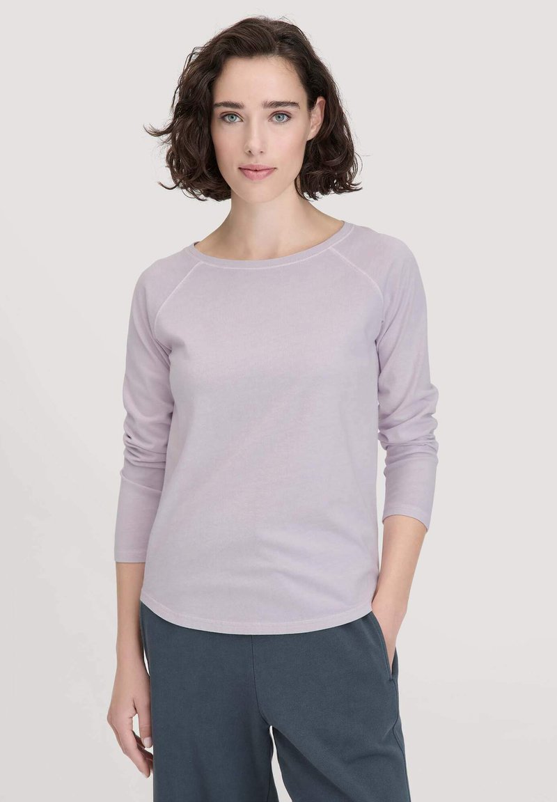 Helllila Langarmshirt mit gerundetem Halsausschnitt und Raglanärmeln, aus weichem Stoff gefertigt. Das Design zeichnet sich durch minimalistische Linien und eine lockere Passform aus.