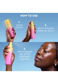 Des mains tenant un vaporisateur rose et jaune démontrent comment secouer, vaporiser 3 à 5 pulvérisations à 20-30 cm, et appliquer un spray fixateur de maquillage sur le visage d'une femme.