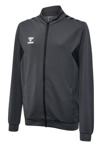 Mørkegrå sportjakke med fuld lynlås, sorte detaljer, sidelommer, ribstrikkede manchetter og et hvidt Hummel-logo på venstre bryst.