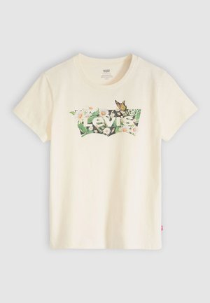 T-shirt en coton crème avec un motif floral et papillon, avec le logo "Levi's" au centre. Manches courtes et encolure ronde.