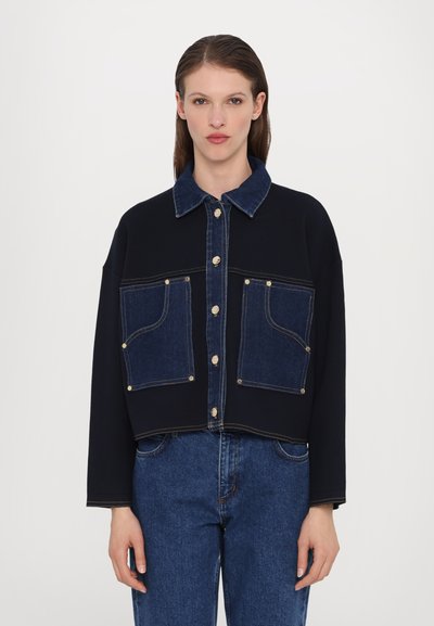 Giacca accorciata con corpo blu scuro, pannelli in denim, chiusura con bottoni e due tasche frontali. Texture morbida con dettagli di cucitura a contrasto.