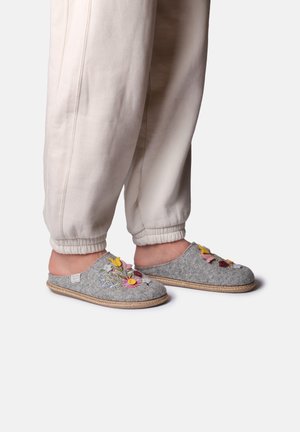 Gray felt slippers with floral embroidery and braided trim. Lightweight design with an open back for easy wear. Paired with white joggers.