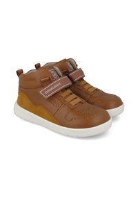 Zapatillas de media caña de cuero marrón con acentos de ante de color marrón claro, suela de goma blanca, cierres de cordón y Velcro, diseño de puntera perforada.