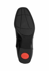 Semelle de chaussure habillée noire avec un motif de grip texturé, taille 37 marquée, et un insert circulaire rouge étiqueté "Tamaris Comfort" sur le talon.