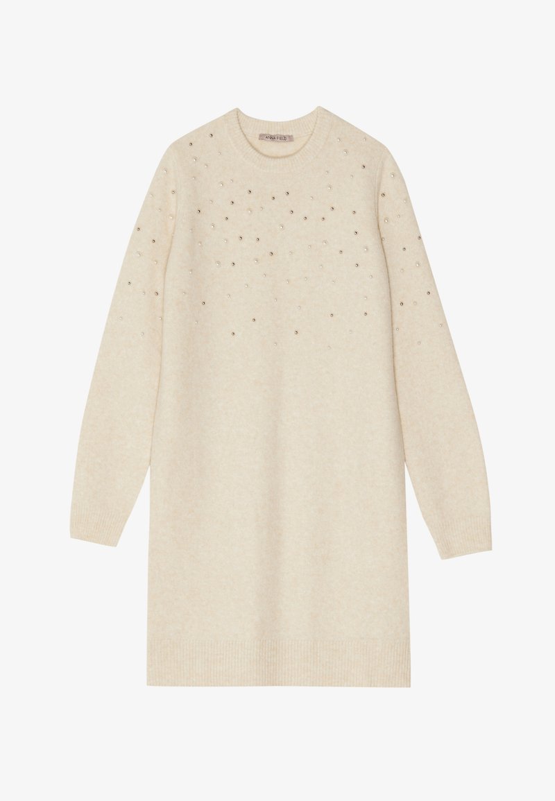 Cremefarvet strikket kjole med lange ærmer, rund halsudskæring og spredte metallisk dekorationer på den øverste del.