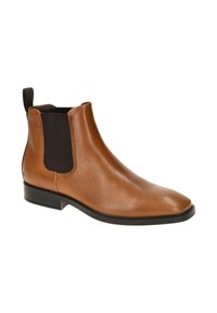 Stivale Chelsea in pelle marrone con pannelli elastici laterali e linguetta. Punta arrotondata e tacco nero basso. Texture liscia con dettagli di cucitura minimi.