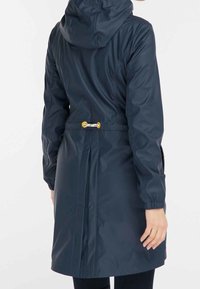 Manteau imperméable marine avec capuche, poignets élastiques et taille à cordon. Présente un dos plissé et des accents en métal doré. Texture lisse.