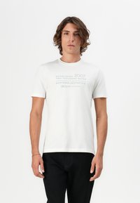 Camiseta blanca de algodón con mangas cortas y cuello redondo, que presenta un texto gráfico en azul y gris: "2007" y "ESTÉTICAS NORTEÑAS."