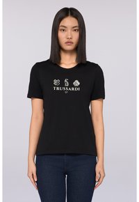 Černé bavlněné tričko s krátkým rukávem, na přední straně má grafiku se třemi logy a slovo "TRUSSARDI" v bílé barvě.