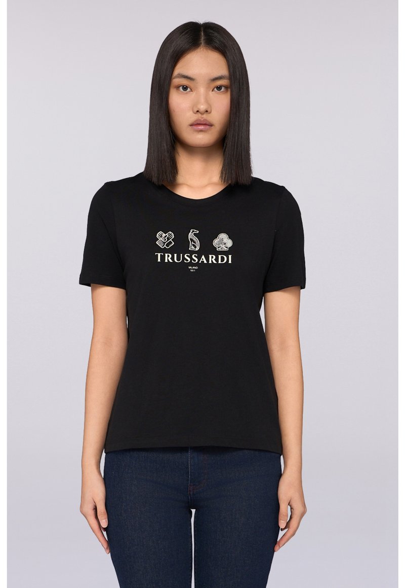 Černé bavlněné tričko s krátkým rukávem, na přední straně má grafiku se třemi logy a slovo "TRUSSARDI" v bílé barvě.