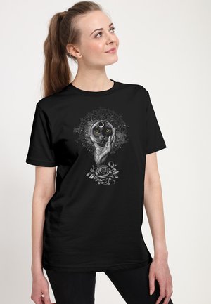 Czarny bawełniany t-shirt z szczegółową grafiką ręki trzymającej czarnego kota z żółtymi oczami, otoczonego ozdobnymi srebrnymi wzorami i różami.