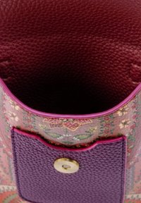 Offene Tasche aus stoff mit Blumenmuster, mit einem strukturierten lila Lederklappdeckel und einem goldenen Magnetverschluss.