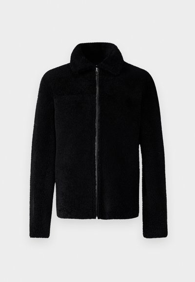 Veste zippée noire en polaire douce et texturée avec un col et des manches longues. Présente un design simple sans logos visibles.