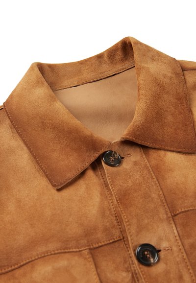 Brauner Wildlederkragen mit glatter Textur, schwarzer Knopfschließe und gesteppten Details in einem klaren, strukturierten Design.