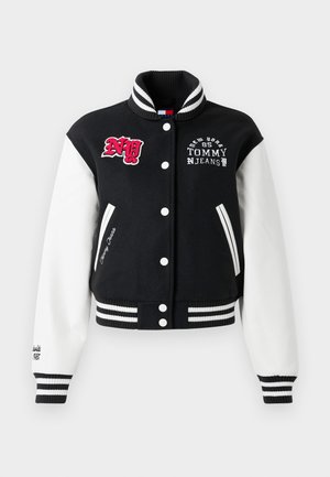 Casaco varsity em preto e branco com gola canelada, fecho de botões e detalhes bordados, apresentando punhos e bainha listados.