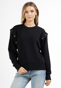 Zwarte sweatshirt met ronde hals, lange mouwen en gouden knoopaccenten langs de schouders. Zachte stof met een ontspannen pasvorm.