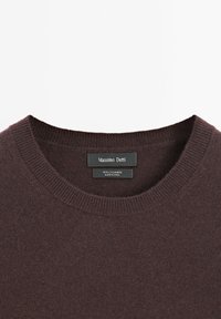 Maglione in cashmere marrone scuro con collo rotondo a costine, dotato di etichette interne con dettagli sul marchio e sul materiale.