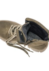 Botte en daim fauve avec lacets beige, partiellement déboutonnée révélant une doublure intérieure douce gris foncé et une semelle intérieure rembourrée.