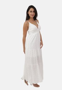 Witte maxi-jurk met een diepe V-hals, verstelbare spaghettibandjes, textuurstof en uitsnijdingen door de hele rok.