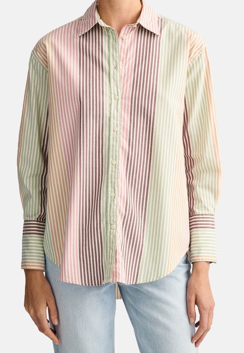 Chemise rayée avec des lignes verticales rose, verte, marron et jaune. Conception à boutons avec col et manches longues. Matériau en coton.