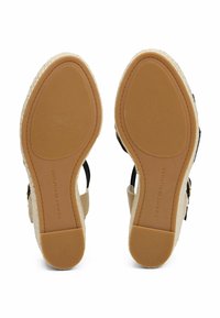 Sandales espadrilles avec une tige en tissu noir, un talon en jute naturel et une semelle en caoutchouc dotée d'un design de grip texturé.