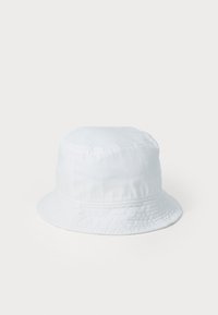 White bucket hat made of soft fabric. Features a rounded top and a wide, flat brim with a textured band around the crown.