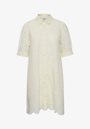 Mornarica s krátkym rukávom v svetložltej farbe s vyšitými očkovými vzormi a okrajom so scallopom.