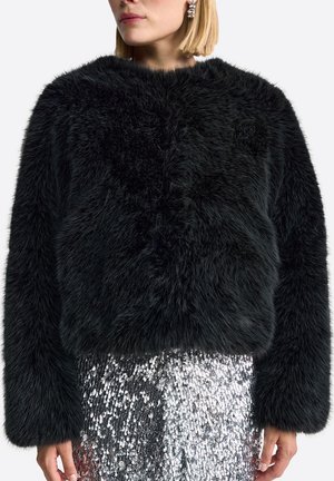 Black faux fur cropped jacket with a fluffy texture, rounded neckline, and long sleeves, paired with a silver sequined skirt.