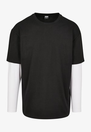 Schwarzes T-Shirt mit kurzen Ärmeln, darunter mit einer weißen Langarm-Schicht. Aus Baumwolle gefertigt, mit Rundhalsausschnitt und lockerer Passform.