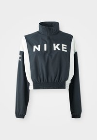 Veste courte Nike avec col haut, corps bleu marine foncé, manches blanches, ourlet élastique, grand logo à l'avant et petits accents textuels sur les manches.