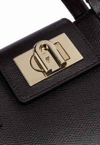 Sac à main en cuir texturé noir avec une fermeture et des ferrures de couleur dorée, de forme rectangulaire et au design élégant.