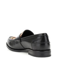 Svarta läderloafers med en slät yta, detaljerad sömnad och en låg svart gummihäl. Insidan har ett leopardmönster.